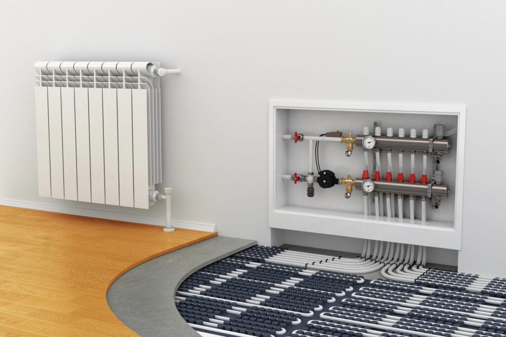 Radiator connected to underfloor heating system with manifold and pipes in room wall.
