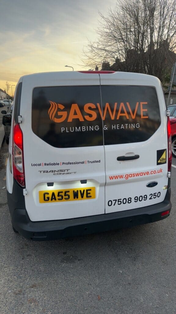 Gaswave plumbing and heating van, white with orange logo, parked outdoors during sunset.
